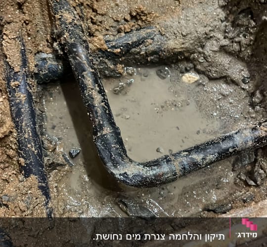 צינור מתכת מכופף בתוך בוץ רטוב